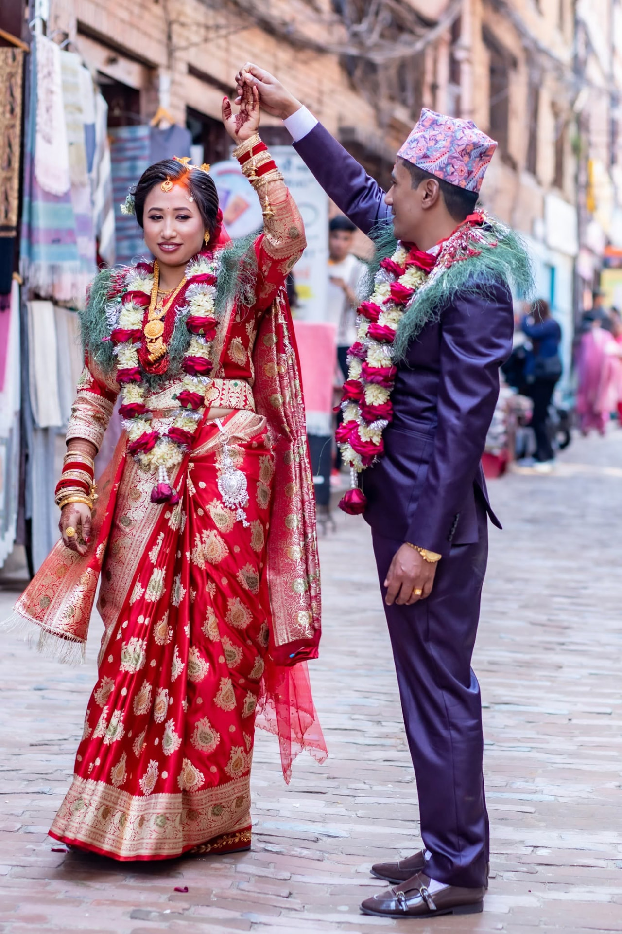 Bride and groom in traditional Nepali attire in a Bhaktapur street