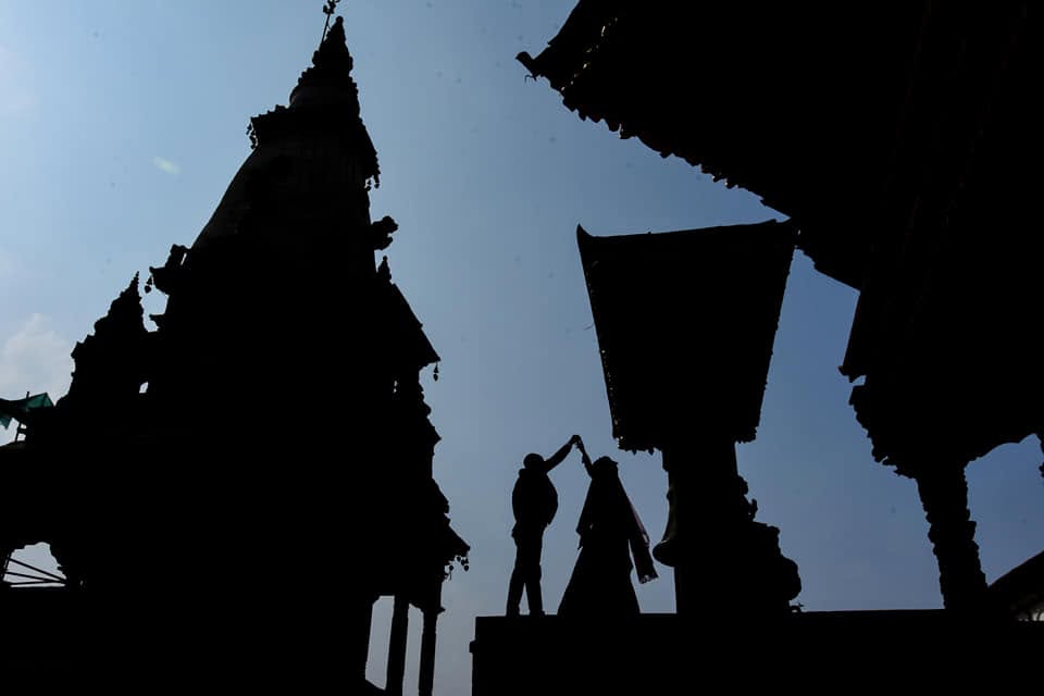 Couple silhouetted between temple rooftops