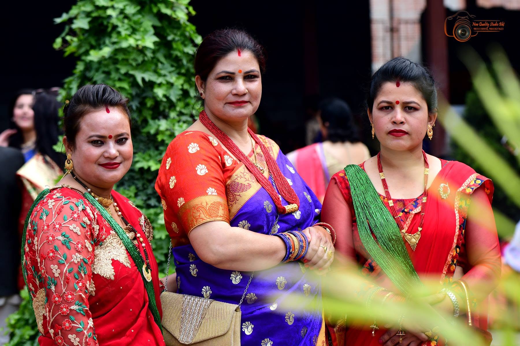 Three women in traditional saris at a family celebration